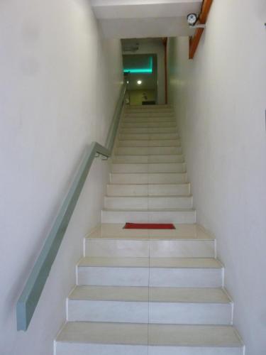 a stair case with a red rug on the floor at The b'Hotel in Kajang