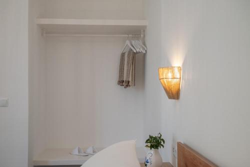a bedroom with a bed and a light on the wall at Limonletto in Patmos