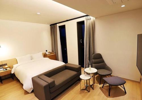 a hotel room with a bed and a couch at Gangneung Grey Hotel in Gangneung
