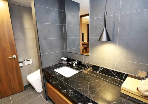 a bathroom with a sink and a mirror at Gangneung Grey Hotel in Gangneung