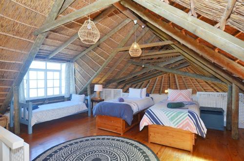 a attic room with two beds and a window at 61 Lutie Katz in Yzerfontein