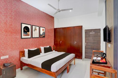a bedroom with a bed and a red wall at Townhouse Manipal University Highway King Bagru Formerly Golden Hotel in Jaipur