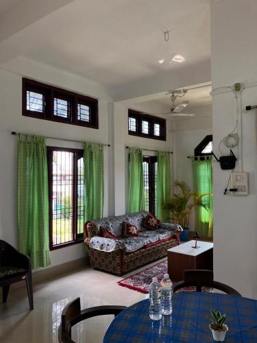a living room with a couch and a table at Green Stay,AC room in Sibsāgar