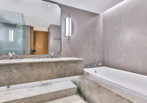 a bathroom with a tub and a sink and a mirror at 대구 빌리언웨스턴호텔 in Daegu