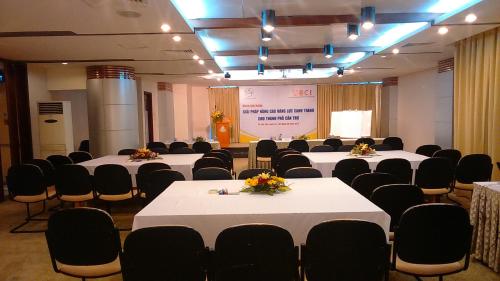una sala de conferencias con mesas, sillas y una pantalla en Kim Tho Hotel, en Can Tho