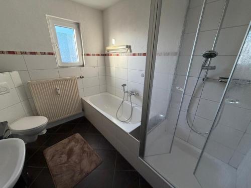 a bathroom with a shower and a tub and a toilet at Ferienwohnung Alina in Hilders