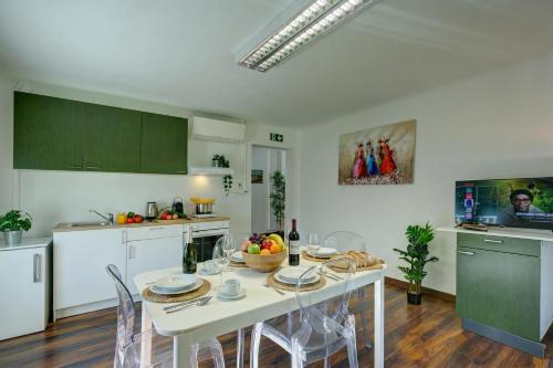 a kitchen with a white table and chairs in a room at Maroggia Apartments in Maroggia