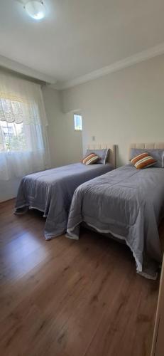 a bedroom with two beds and a window at Moraes Residence in Belo Horizonte