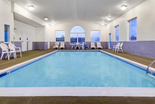 a pool with chairs and tables and chairs in a building at Microtel Inn & Suites by Wyndham London in London