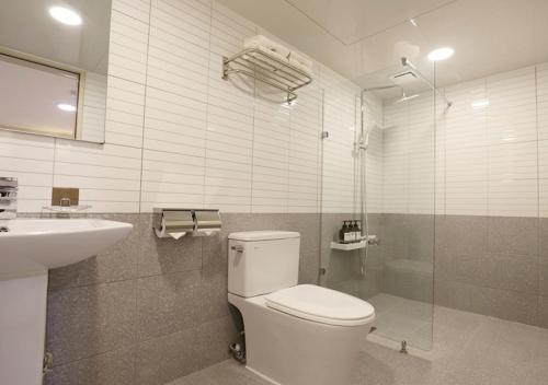 ein Badezimmer mit Toilette, Waschbecken und Dusche in der Unterkunft Chuncheon Pine Tree Hotel in Chuncheon