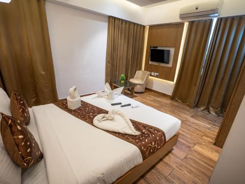 a hotel room with a bed and a television at GRAND ONE TOWER in Chennai