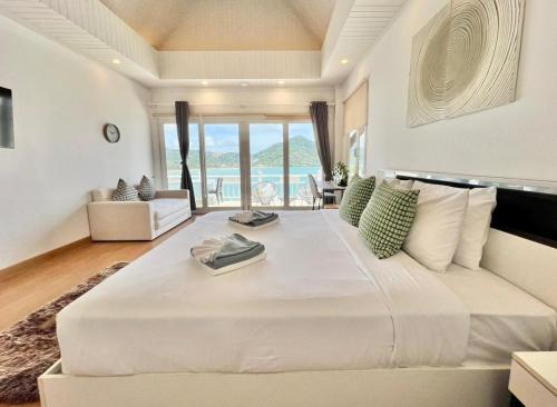 a large white bedroom with a large bed with a view at Villa H in Surin Beach