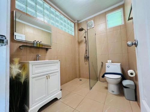 a bathroom with a toilet and a glass shower at Villa H in Surin Beach
