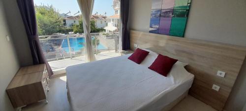 a bedroom with a bed and a large window at Ölüdeniz Günlük Kiralık Daire & Apart havuzlu in Oludeniz