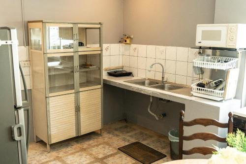 a small kitchen with a sink and a microwave at Phuket Monaburi Boutique Hotel in Rawai Beach