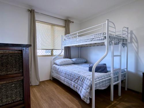 a bedroom with a bunk bed with a ladder at Sound Views Apartment in Safety Bay