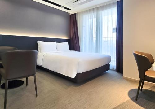 a hotel room with a bed and a table and chairs at Kinstay Hotel in Goyang