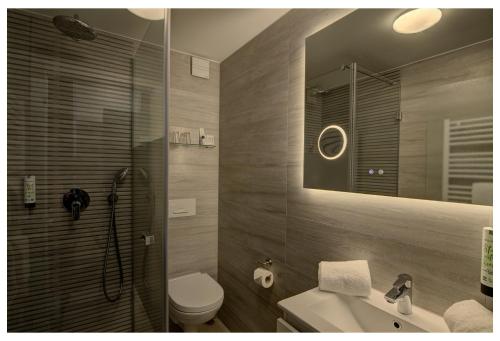 a bathroom with a shower and a toilet and a sink at Waldhotel Wandlitz in Wandlitz