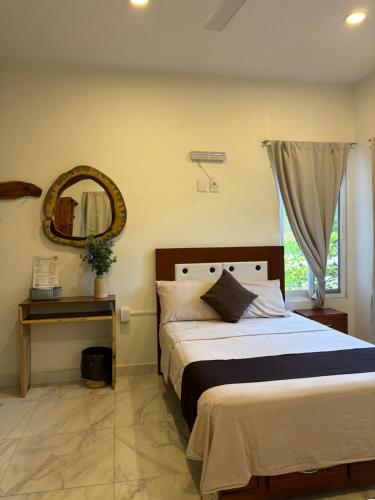 a bedroom with a bed and a mirror on the wall at Cocos House Zicatela in Puerto Escondido