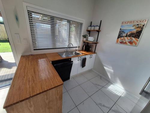 a small kitchen with a sink and a window at Beach Pad in Whangamata