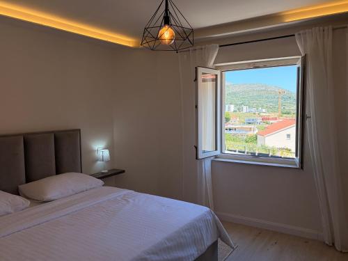 a bedroom with a bed and a large window at Apartment Cascades in Trogir