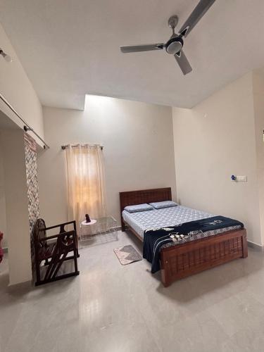 a bedroom with a bed and a ceiling fan at R's Bolli Kudike in Madikeri
