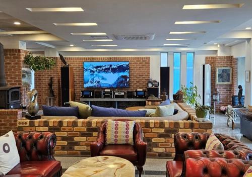 a living room with couches and a tv on a brick wall at HwiMokArt Resort in Buan