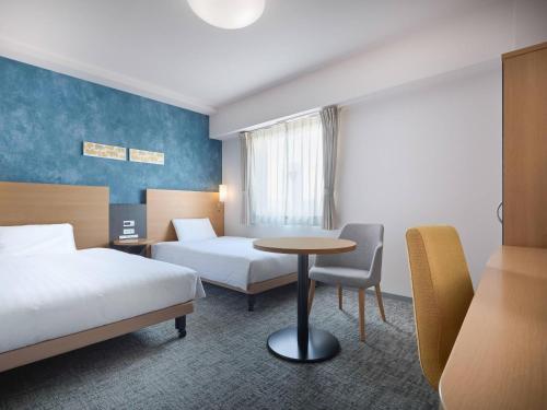 a hotel room with two beds and a table at Comfort Hotel Koriyama in Koriyama