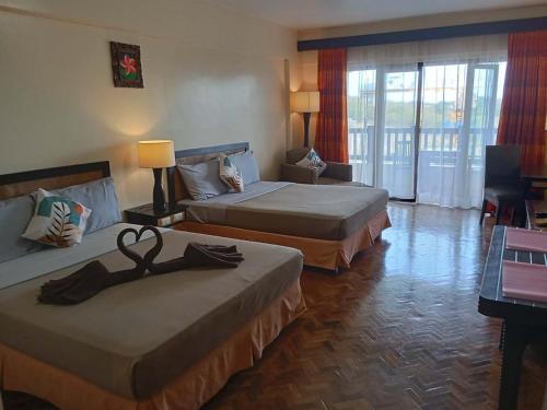 a hotel room with two beds with swans on them at Alta Vista Residences H102 in Boracay