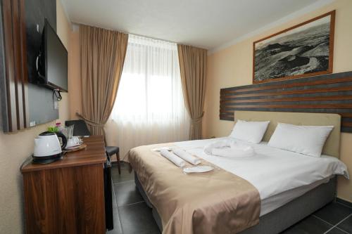 a hotel room with a bed and a television at Hotel Santa Ria in Kŭrdzhali