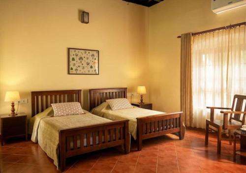 a bedroom with two beds and a window at Villa Mariam in Cheruvalli