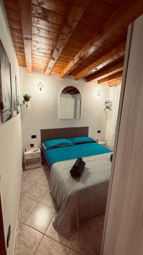 a bedroom with a large bed with a blue blanket at The Mastiffs in Chioggia
