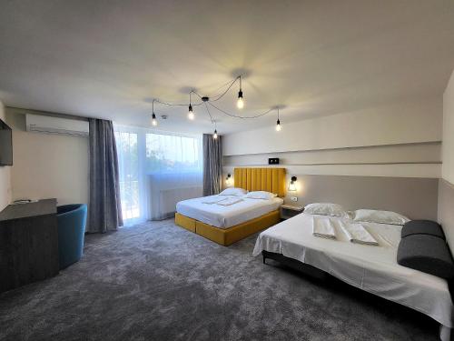 a hotel room with two beds and a television at XO Residence in Arad
