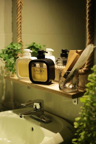 a bathroom sink with a soap dispenser on a mirror at Behomestay in Hai Phong