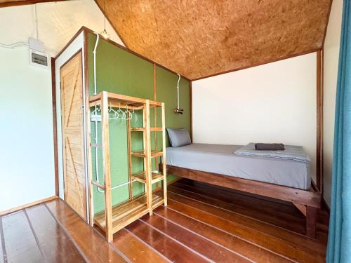 a small room with a bed and a book shelf at Yod Khao Muay Thai Camp in Ban Nok