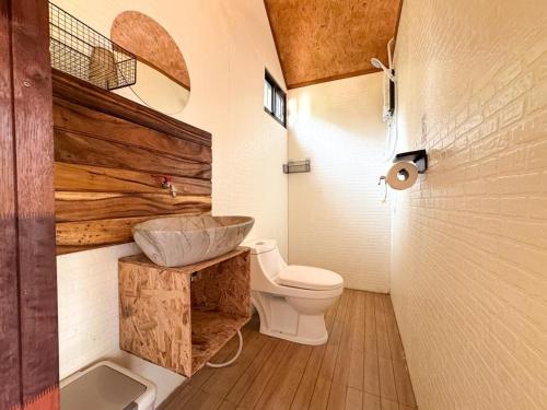 a bathroom with a white toilet and a sink at Yod Khao Muay Thai Camp in Ban Nok