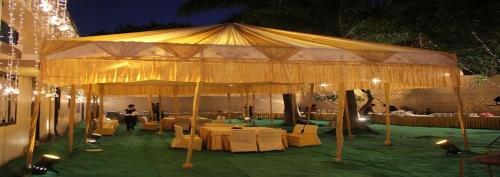a large tent with tables and chairs under it at Hotel Sukoon in Dehradun