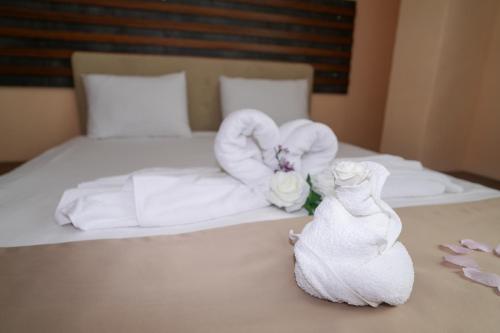 a hotel room with a bed with towels and a bride at Hotel Santa Ria in Kŭrdzhali