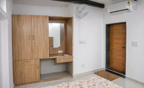 a bathroom with a wooden cabinet and a mirror at Lighthouse Hostel in Udaipur