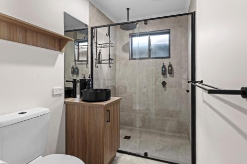 a bathroom with a shower with a toilet and a sink at Barooga Hotel in Barooga