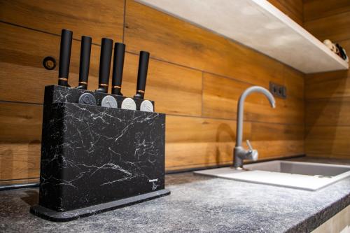 a kitchen counter with a knife block next to a sink at Desimo Home in Piła