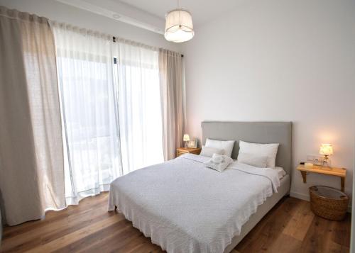 a bedroom with a white bed and a large window at Aqualina E4-1 by HolidayKeys in Kyrenia
