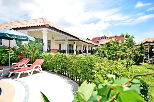 a house with two chairs and a pool at Baan Opun Garden Resort in Hua Hin