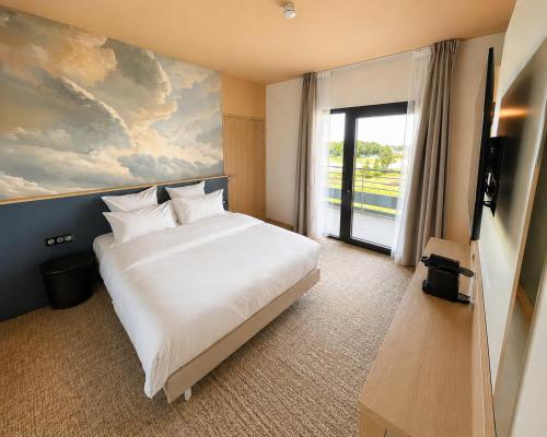 a bedroom with a large white bed and a window at The Originals Boutique, Osmo Hôtel, Rennes Sud Chantepie in Chantepie