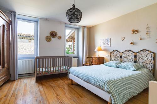 a bedroom with a bed and a crib in it at Gîte la Pigne in Aurel