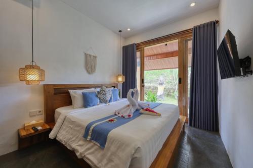 a bedroom with a bed with a bird on it at Kampuak Cottages in Nusa Penida