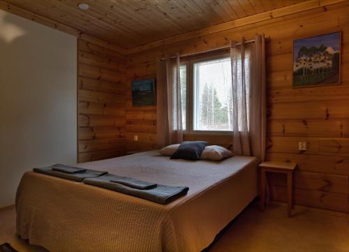 a bedroom with a bed in a log cabin at Venetsianranta in Saarijärvi
