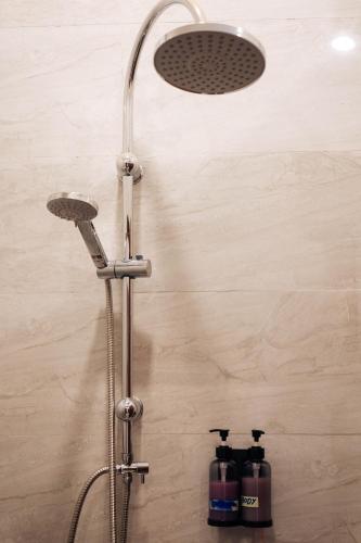 a shower in a bathroom with two bottles of water at Nam Phou Hostel in Thakhek