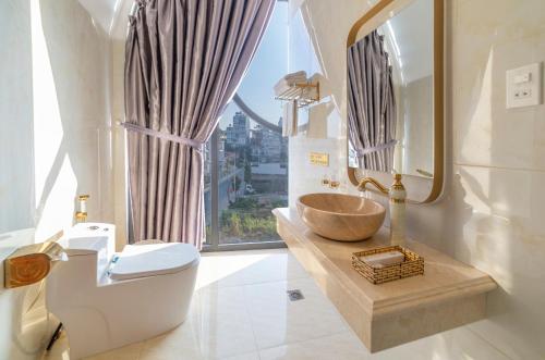a bathroom with a sink and a toilet and a window at Dalat Hotel & Villa by Pham Gia in Xuan An