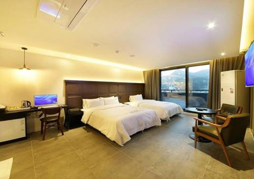 a hotel room with a bed and a desk with a computer at Anyang Boutique Hotel AMA in Anyang